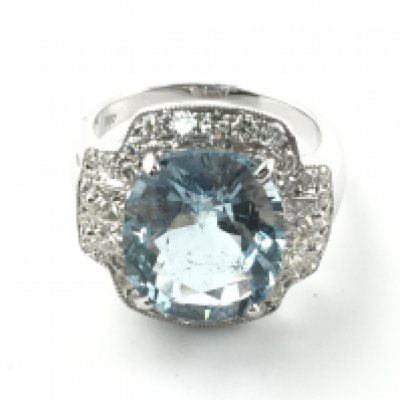 18ct white gold dress ring set with large oval cushion cut aquamarine surrounded by princess and round cut diamonds. Approximately 6.15ct aquamarine and 1ct diamonds. Size M