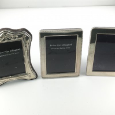 Three hallmarked silver photo frames. Approximately 8cm by 11cm.
