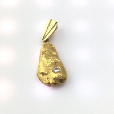A 22ct gold pendant set with a small diamond. 7.20g