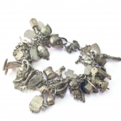 A Stirling silver charm bracelet with a large number of charms. 115.81g