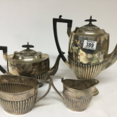 A four peice silver tea set maker Walker Hall Sheffield with half flutes sides and ebony handles.total weight 1980g approximately.