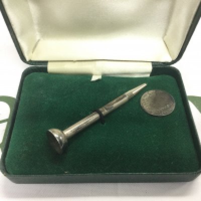 A silver propelling pencil in the form of a golf tee and a silver ball marker (2). Shipping category A.