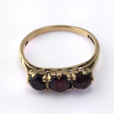 A 9ct gold garnet three stone ring. Size S and 2.87g