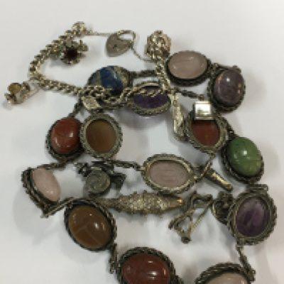 A silver hard stone necklace with matching bracelet and a silver charm bracelet
