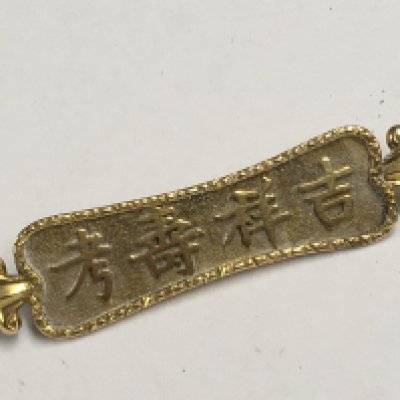An 18ct gold brooch with Chinese characters. 3g approx