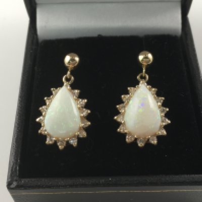 A pair of 14ct yellow gold drop earrings set with pear shaped cabochon opals surround by approx 0.30 diamonds. Opals are approximately 3ct. Postage B