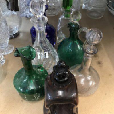 A mixed collection of coloured and cut glass decanters.- NO RESERVE