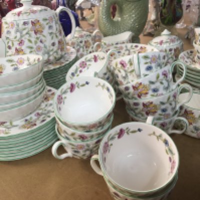 A Minton porcelain dinner and tea service Haddon Hall pattern with flowers on a white ground some second quality, no obvious damage nine dinner plates side plates fourteen cups fourteen saucers tea pot and more.