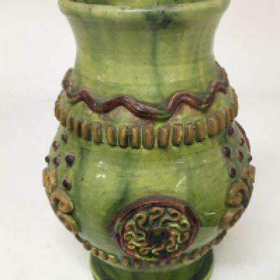 A Victorian art vase Castle Hedingham signed to the base EW Bingham England No 1 decorated in raised relief on a green ground. Some firing cracks and minor damage. Height 18cm