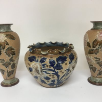A pair of Doulton stoneware vases with raised floral pattern decoration and a conforming jardiniere no obvious damage good condition. Vase height 27cm (3)