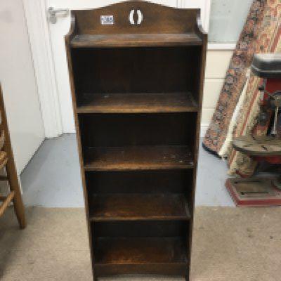An open shelf bookcase and a vintage trunk with key.