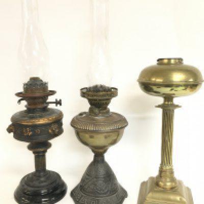 Oil lamps including a late 19th century brass example with engraving, cast iron and brass lamp with a glass shade and a lamp by S.Hooper Birmingham with lion head design and a glass shade . This lot cannot be posted