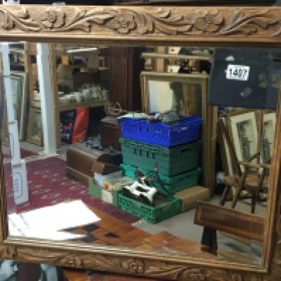 A carved oak wall mirror of rectangular shape with a bevel edge.