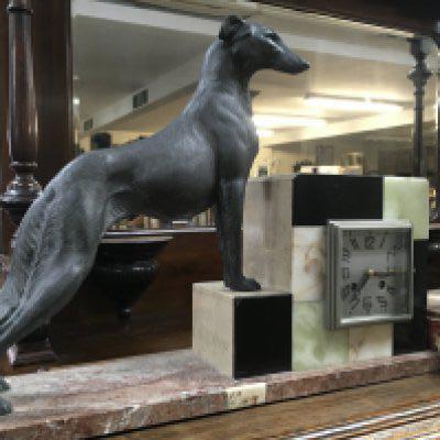 A Art Deco mantel clock the square dial flanked by a dog on a pink marble Base .49 x 36 cm