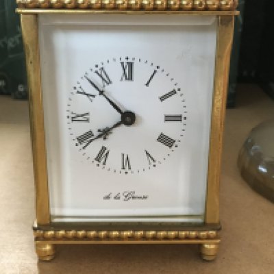 A brass carriage clock the dial with Roman numerals.