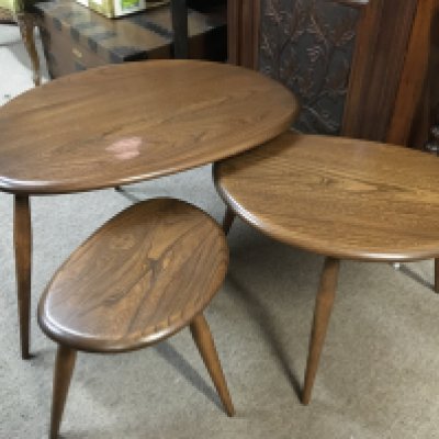 A nest of Ercol pebble tables , damaged top. 40cm tall.