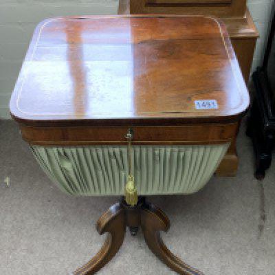 A 19th Century Regency Brass Inlaid Rosewood Lift Top Work Table with three down swept brass inlaid rosewood supports on claw feet and castors.