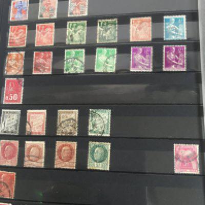 A blue album containing French and Kiribati stamps .