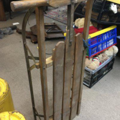 A vintage wooden sledge produced by Grays of Cambridge & The Carlton white lining field wheel by Jag Lillywhite Frowd & Co