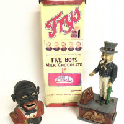 A collection of money boxes including a cast iron Uncle Sam money box, cast iron vintage boy & a Frys reproduction tin chocolate dispenser (40cm tall). Postage category C Notice from the&#2013266080the-saleroom.com:&#2013266080These items are listed on the basis they are illustrative of a bygone culture in which there were different social norms. We understand the potential controversy surrounding this type of item but believe that providing transparent information about historical context fosters greater understanding of our complex cultural history.
