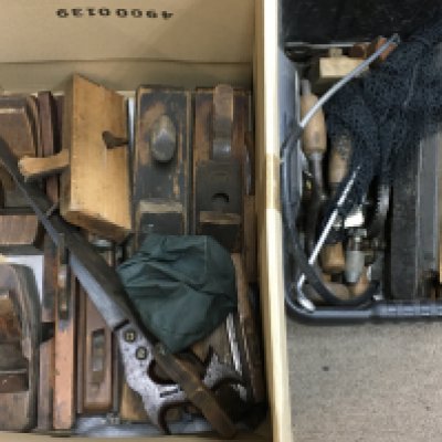 A collection of vintage woodwork tools including wooden planes, saws and other tools