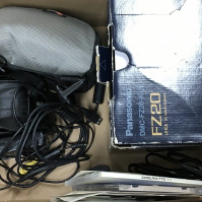 A collection of cameras including a Panasonic Lumix FZ20, Nikon Coolpix 775 and accessories