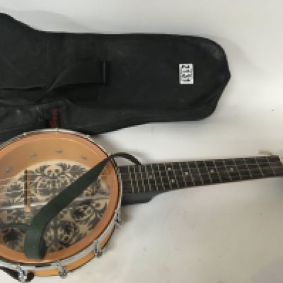 A banjo Ukulele Remo Luna in a fitted case music sheets and stand.
