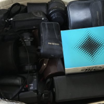 A collection of camera equipment including a boxed Yashica ME1, Praktica MTL3, Praktica Nova FX, lenses Ensinor 500mm mirror lens