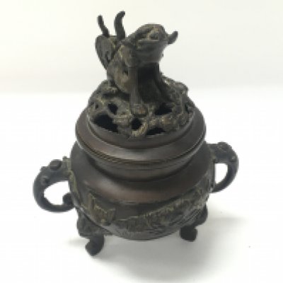 A Japanese bronze incense pot with a foo dog / lion on the lid. Approximately 15cm tall and 12cm wide.