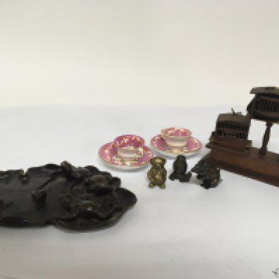 An Oriental bronze in the form of a Lilly pond leaf surmounted with frogs signed base diameter 18cm three other miniature bronze ornaments two miniature cups and saucers and a small model of three bird cadges.