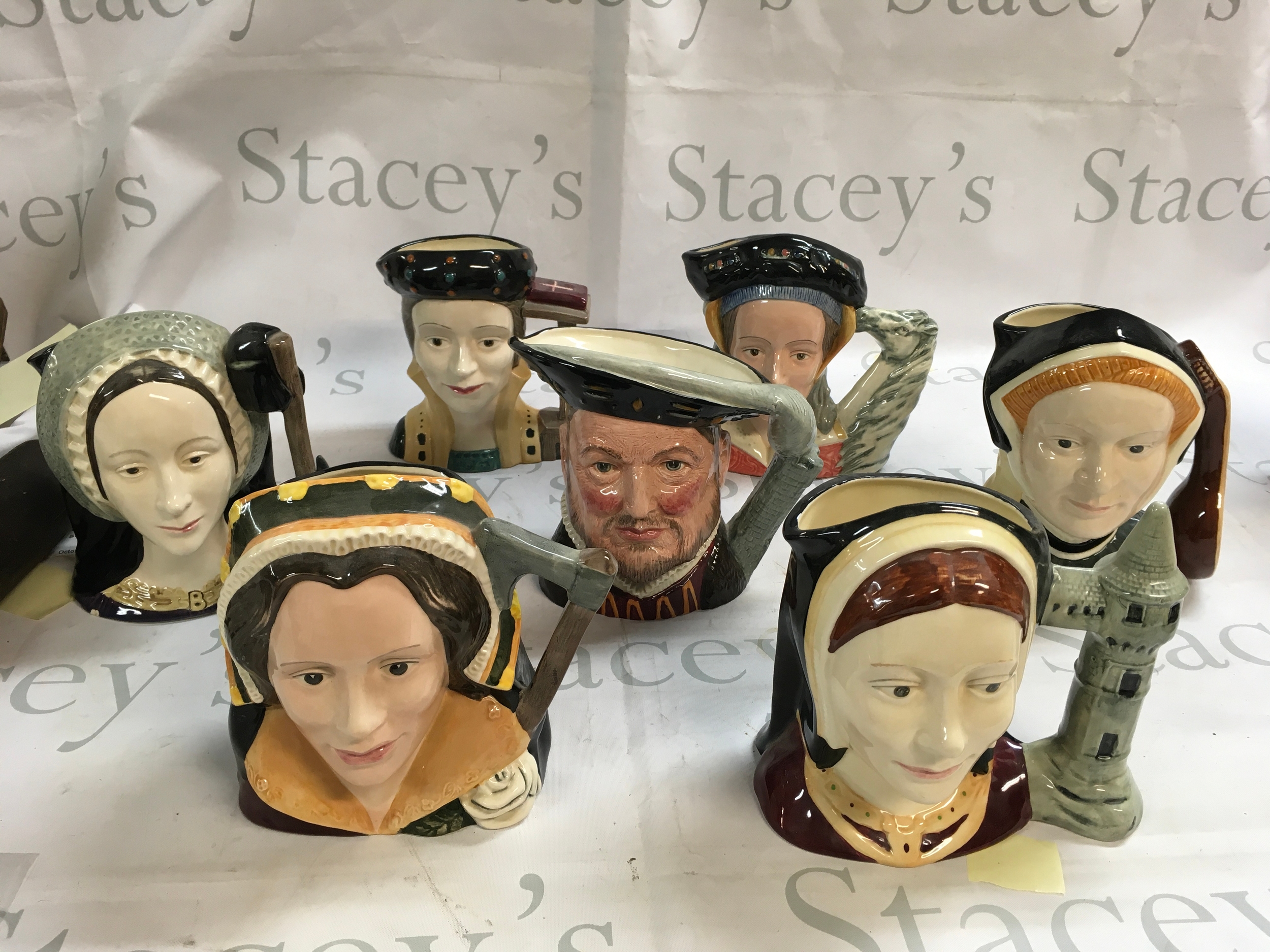 A collection of Doulton Character jugs including Henry VII and his six wives with three additional jugs ( the juggler, the cardinal and the jester )