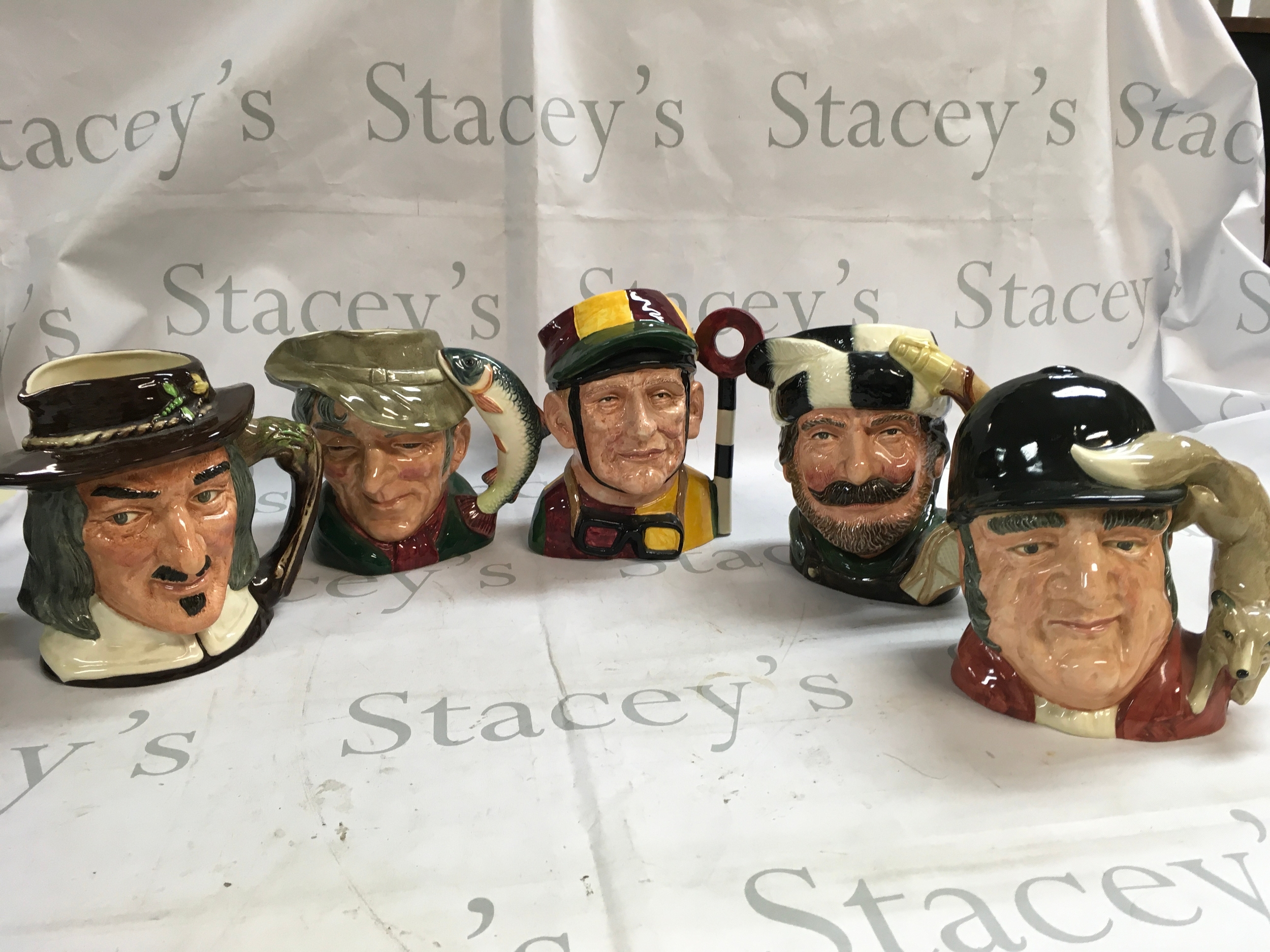 A mixed collection of Doulton character jugs including Izaak Walton, Gone Away, The Trapper, Jockey, and The Poacher. 
