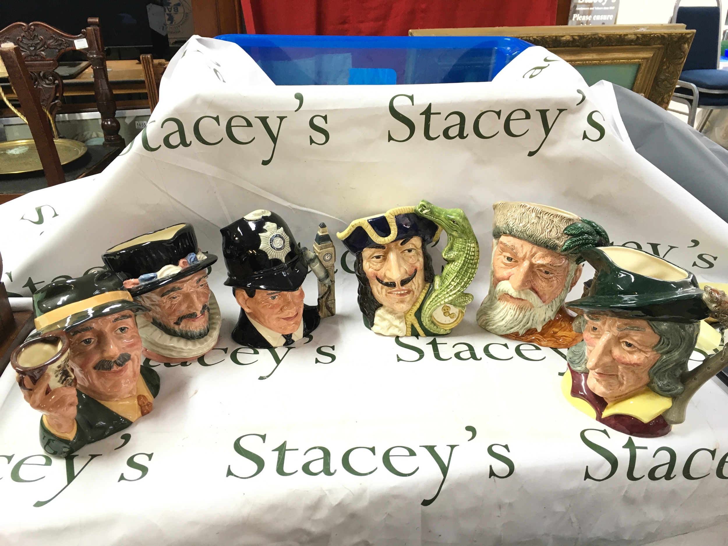 Six Royal Doulton character jugs including The Collector D6796, Pied Piper D6403, Robinson Crusoe D6532, Capt Hook D6597, The London Bobby D6744, Beefeater D6206