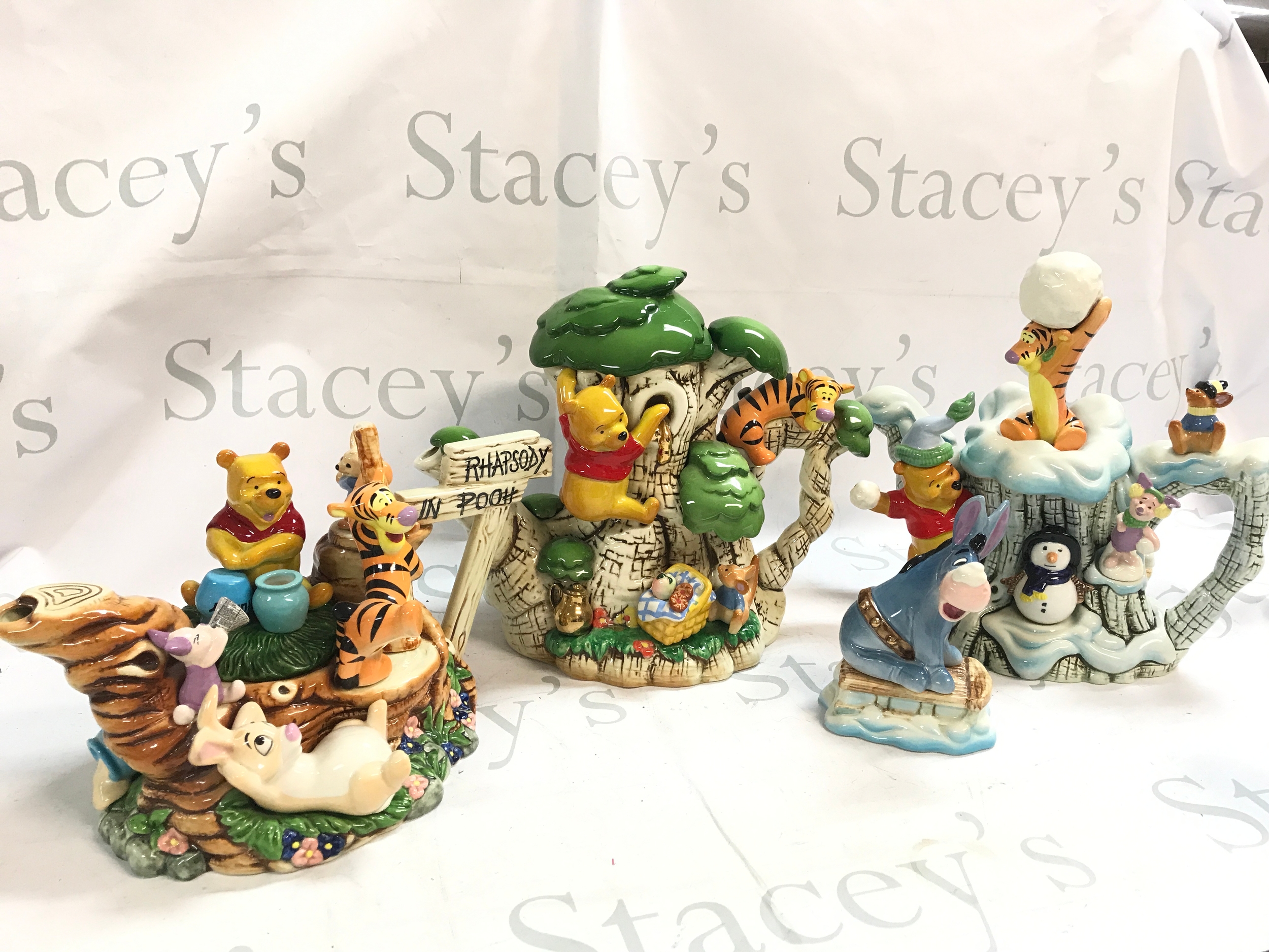 Three Cardew studio Disney ceramic tea pots including Rhapsody In Pooh 152/4950, Summer Pooh 54/100, Winter Pooh 96/100 and a Winter Pooh Eeyore figure. Piglet figure needs re gluing 