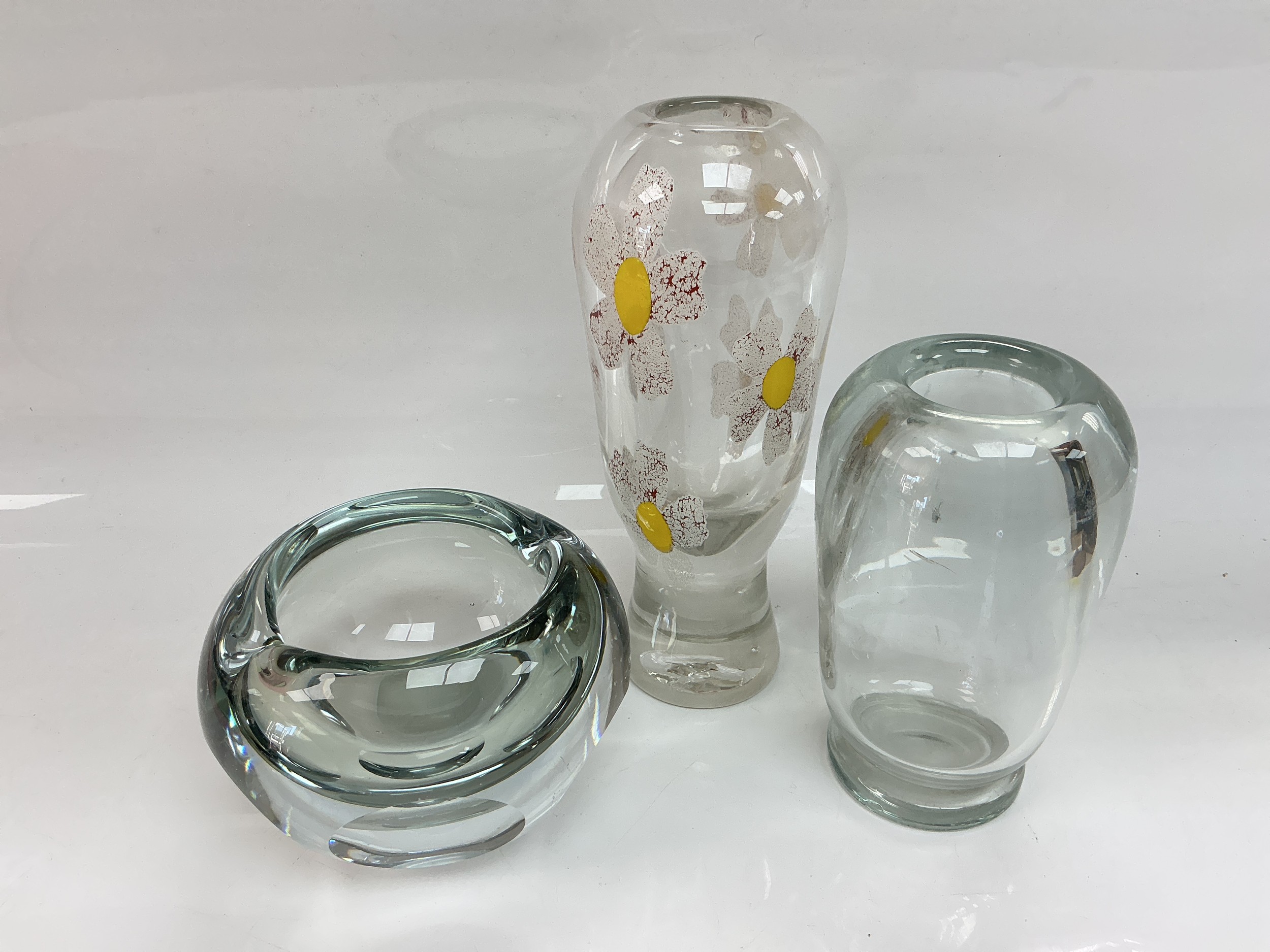 Three clear glass vases, one decorated with daisies, tallest approx 25cm.
