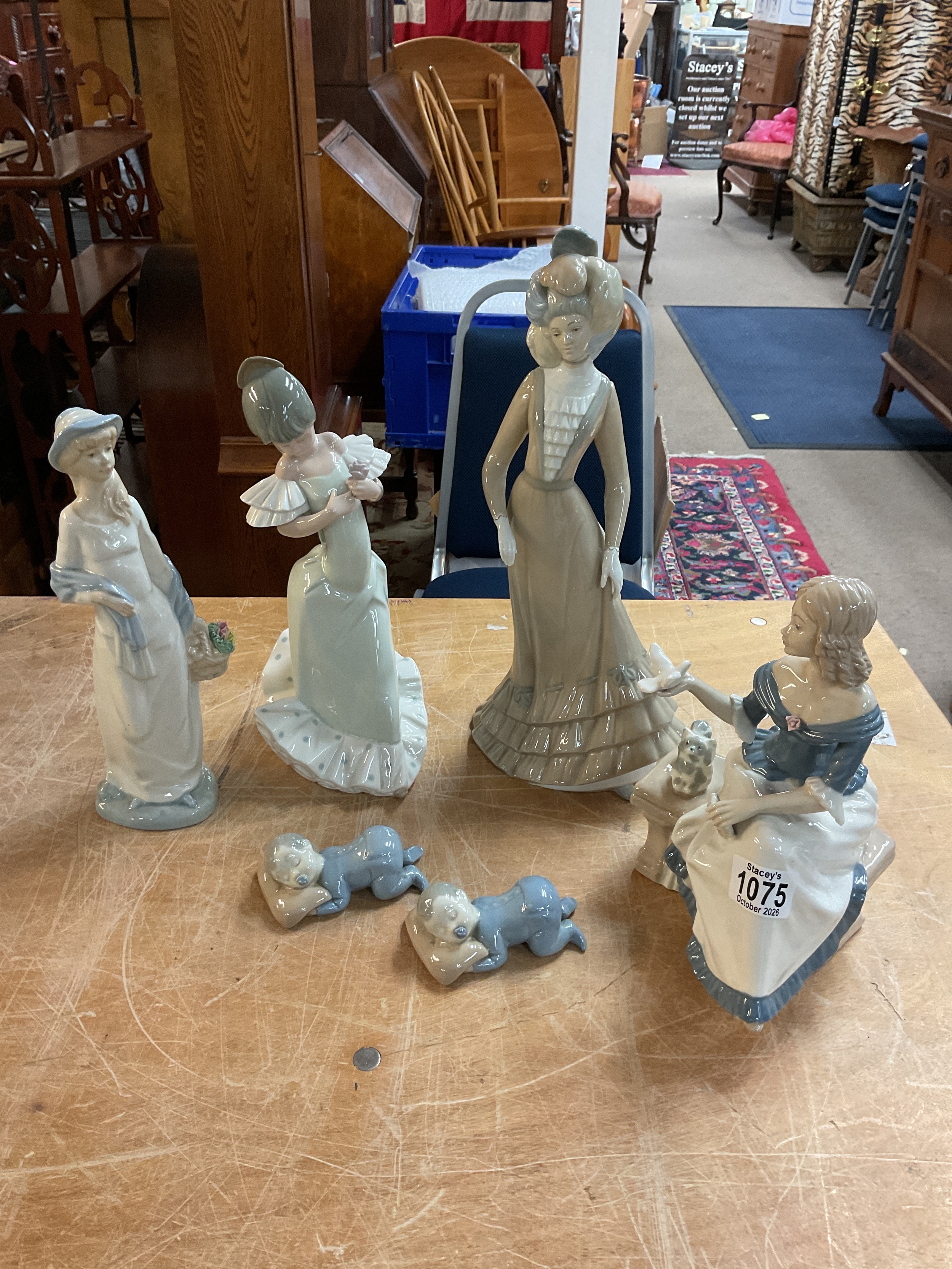 NAO Spanish girl, three Spanish ceramics and two sleeping babies on pillows.