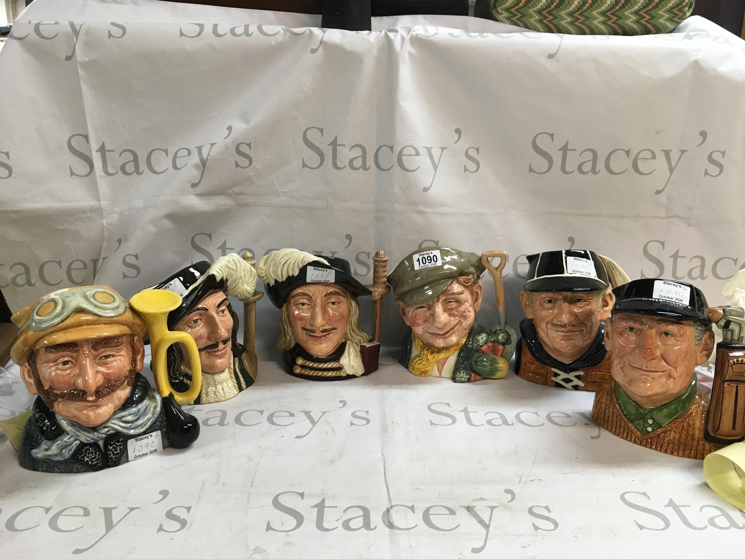 A collection of 6 Doulton character jugs including: the golfer, Yachtsman, the gardener, Armasis, Athos, and Veteran Motorist. 