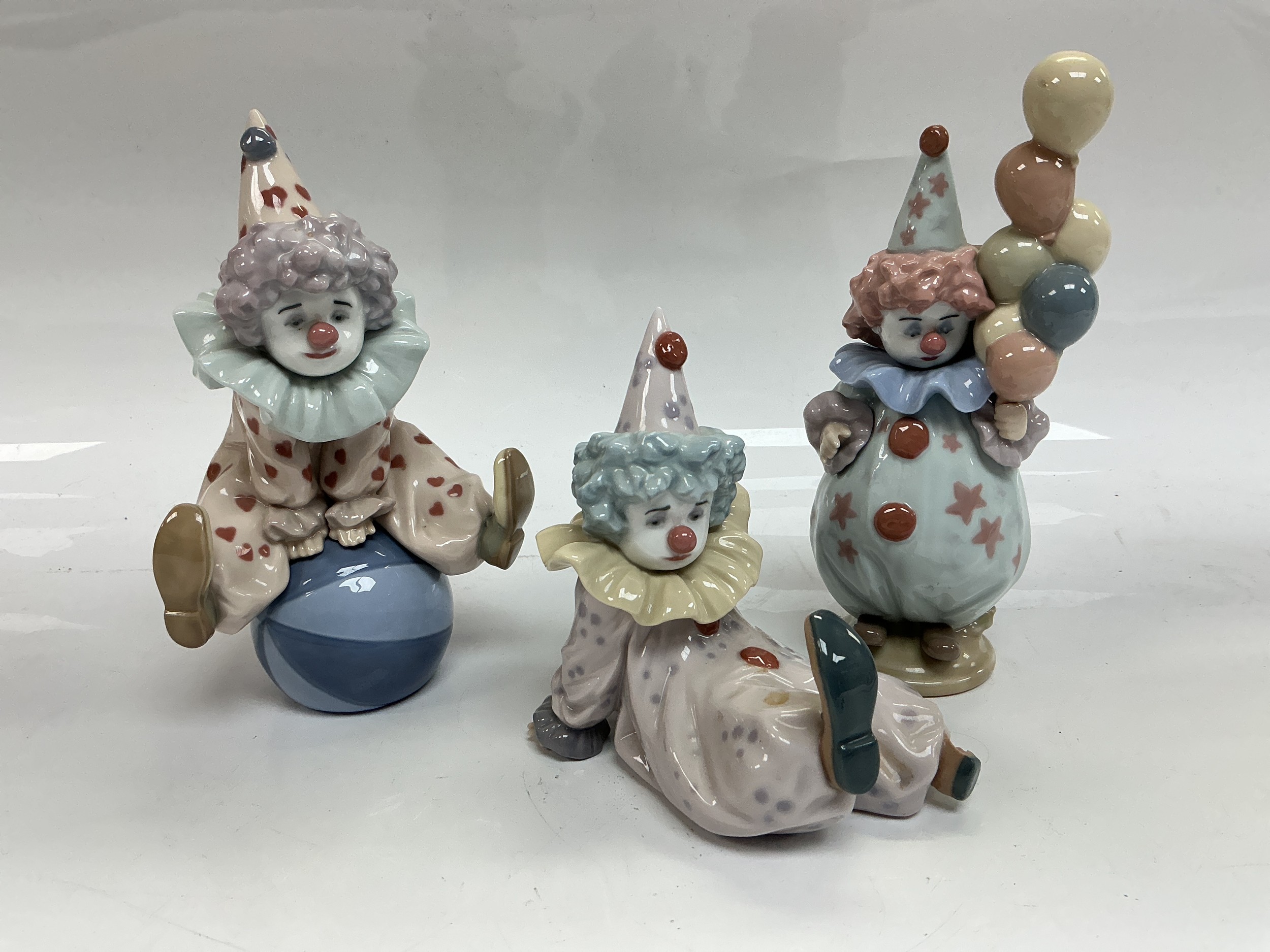 Three Lladro clown figures, tallest approx 18cm.