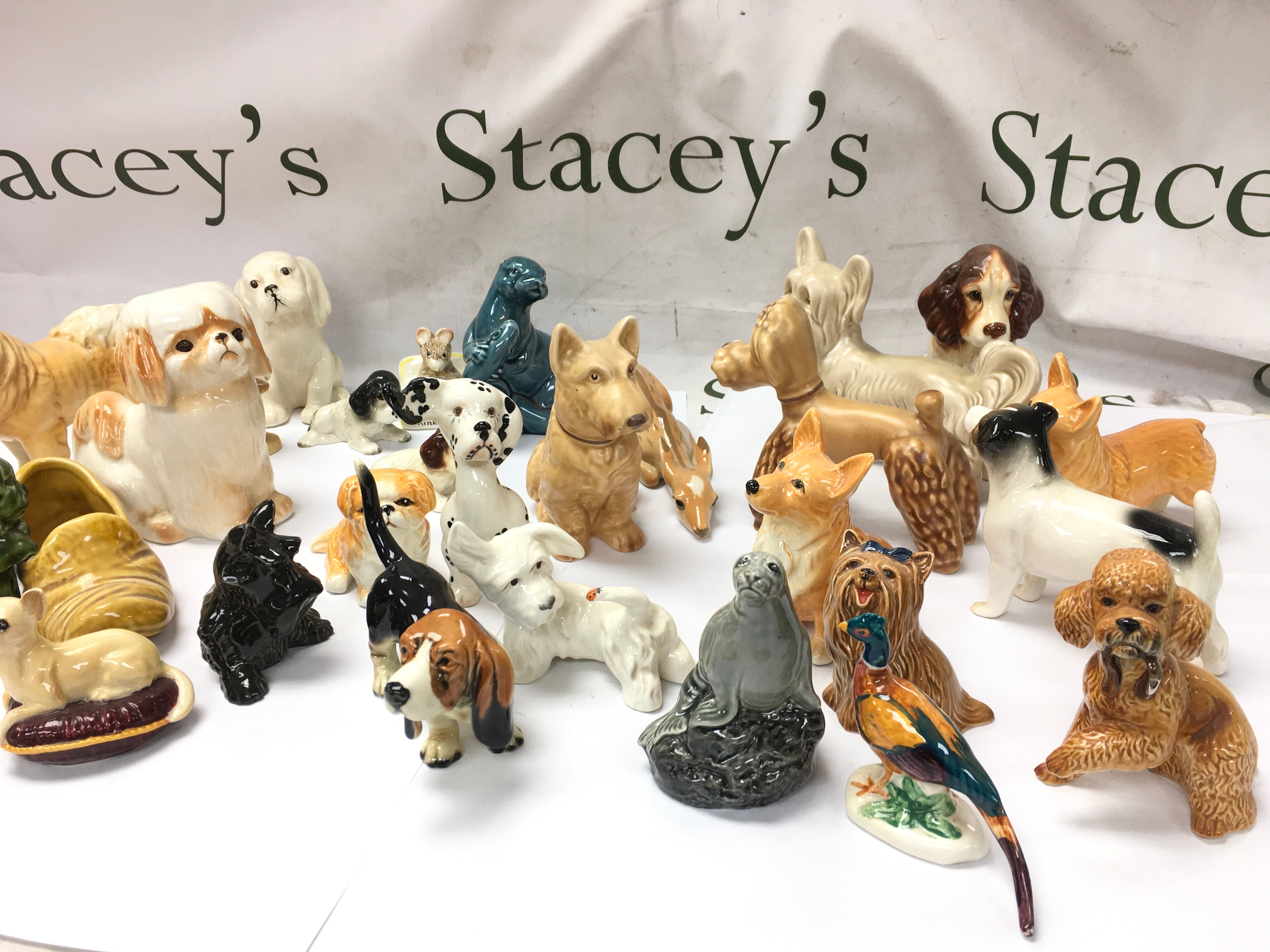 large collection of vintage ceramic, porcelain, and pottery animal figurines, primarily dog breeds including Beswick etc