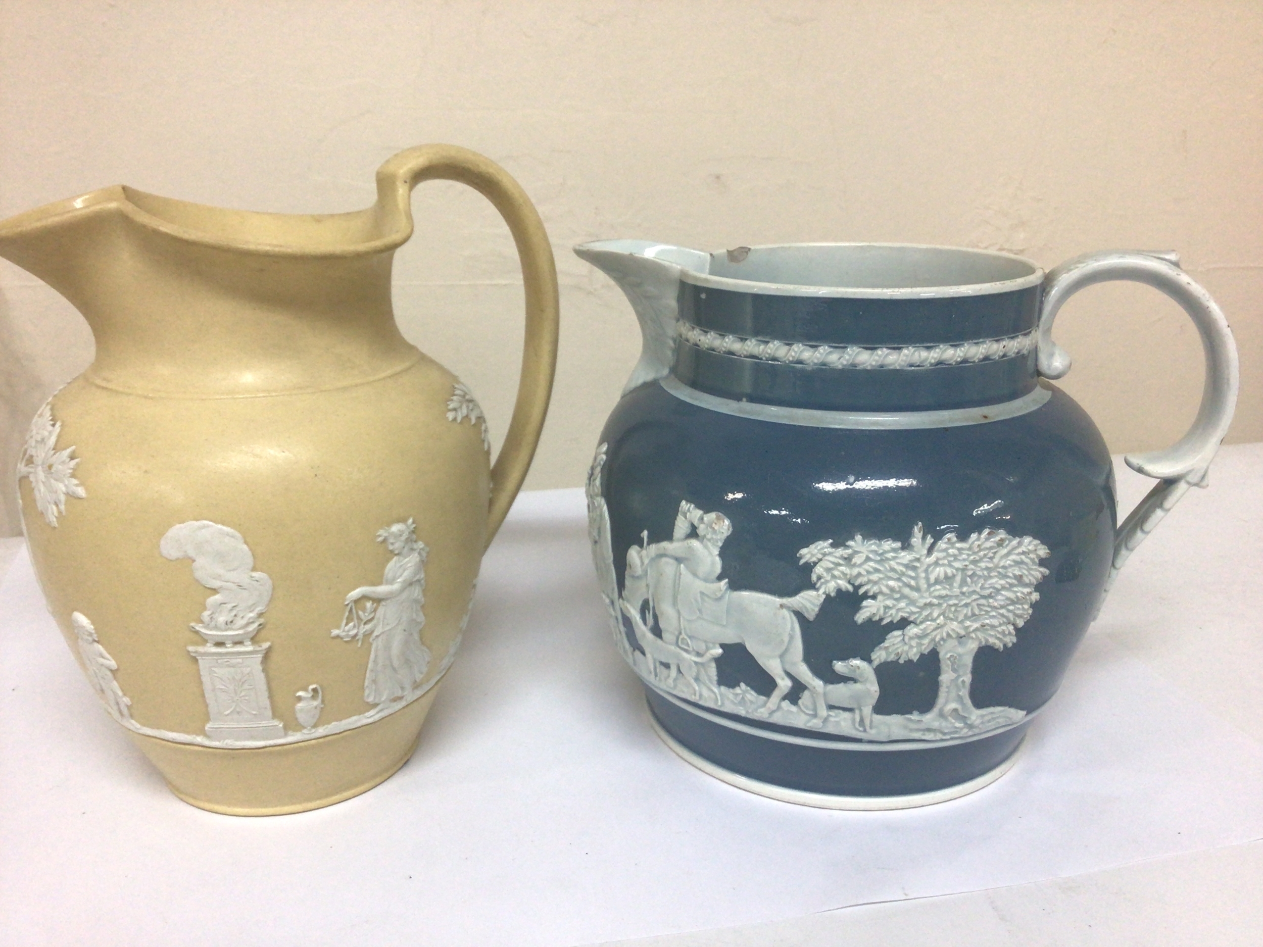 An Early 19th century yellow glazed jasper Wedgwood jug sprig decorated with classic figures and one other 19th century jug (2) 16 and 18cm tall approx