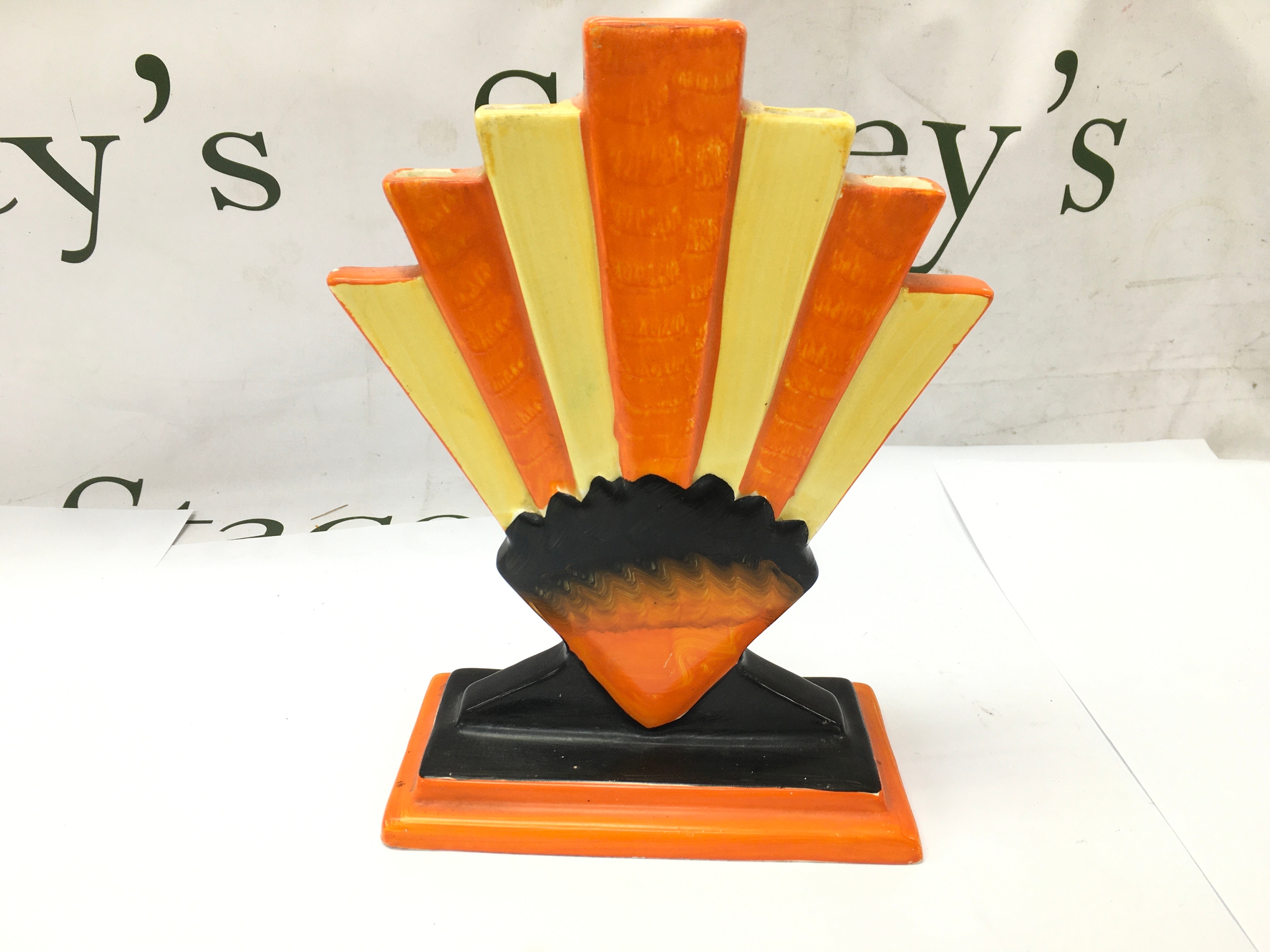 Art Deco hand painted fan vase made by Myott Son & Co (pattern number 8516), featuring a bright orange and yellow fan design set on a black and orange plinth. 22cm tall by 16cm wide.