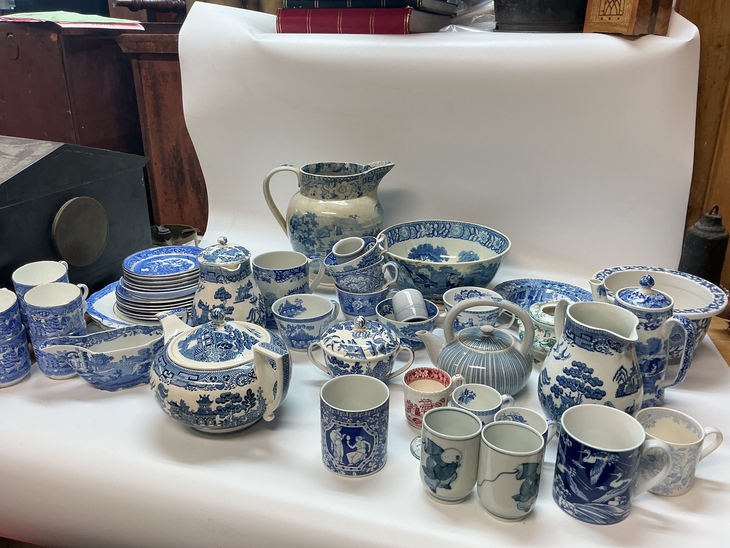 A collection of blue and white ceramics including plates, cups, jugs, tea jugs. Willow Wedgwood, Spode, Sutherland china. 