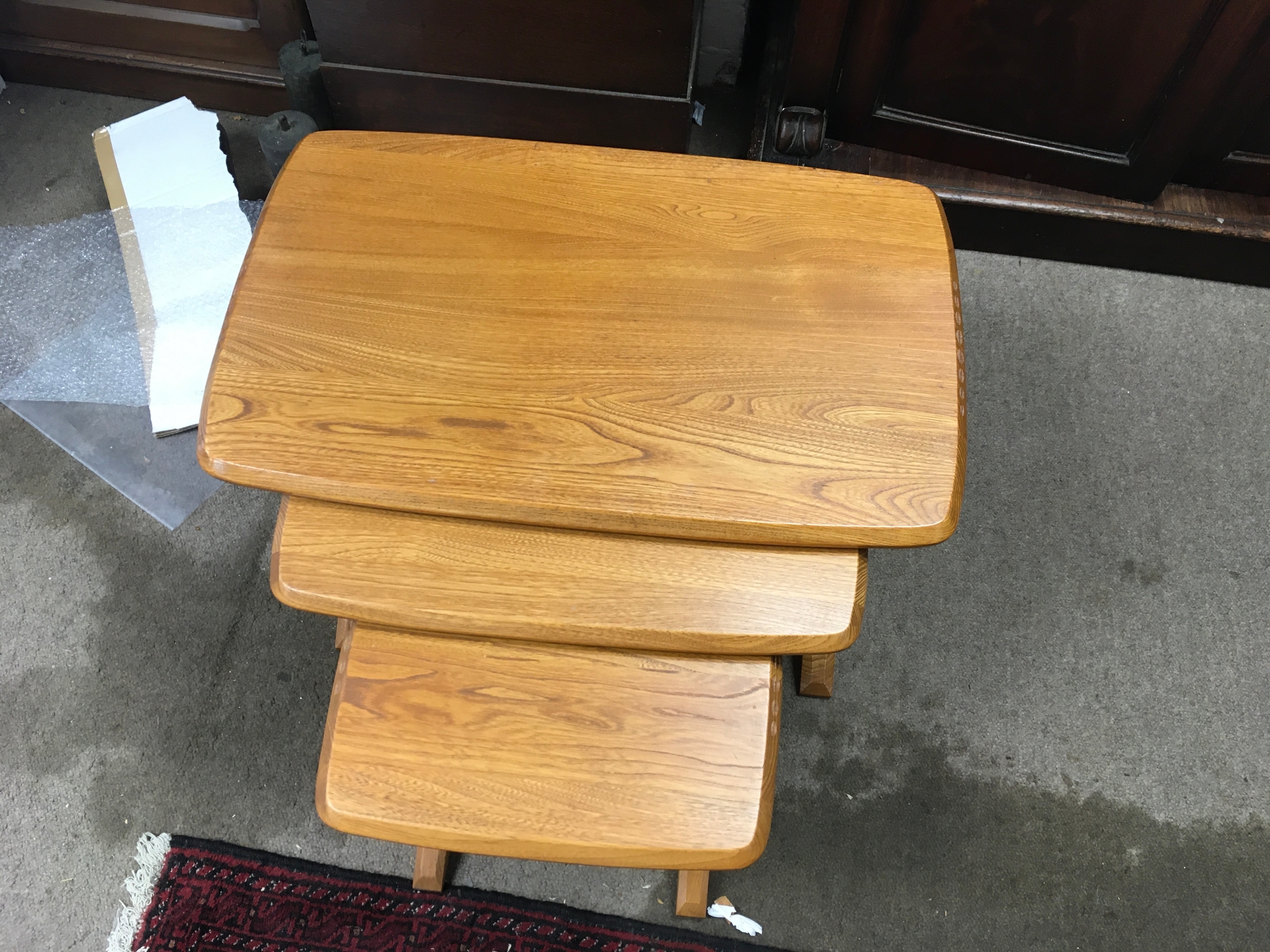 A nest of very light coloured elm Ercol tables. Mid 20th century design. largest being 63cm wide