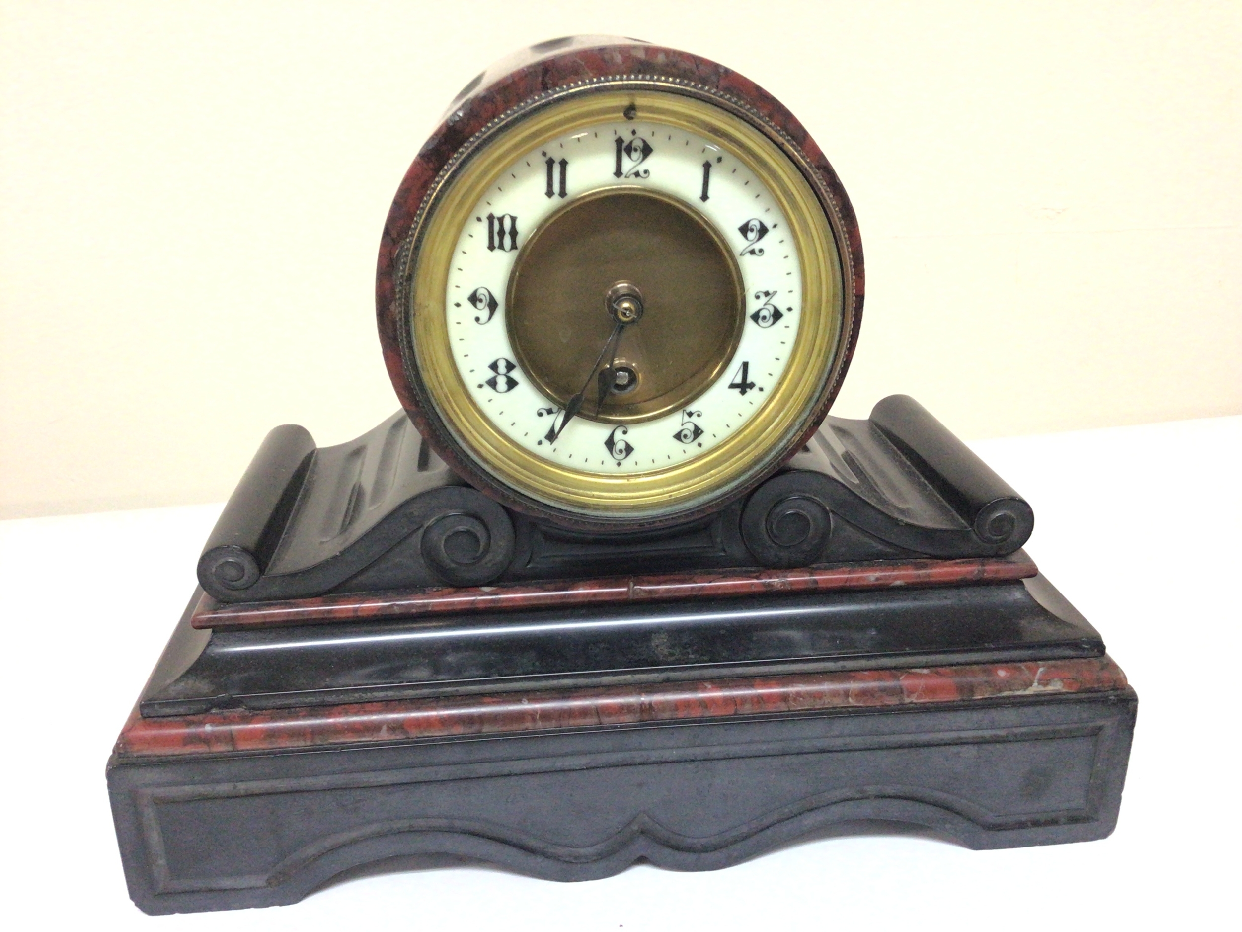 A black slate and marble Victorian mantel clock. 24cm high. Fitted with a French brass movement with pendulum. NO RESERVE