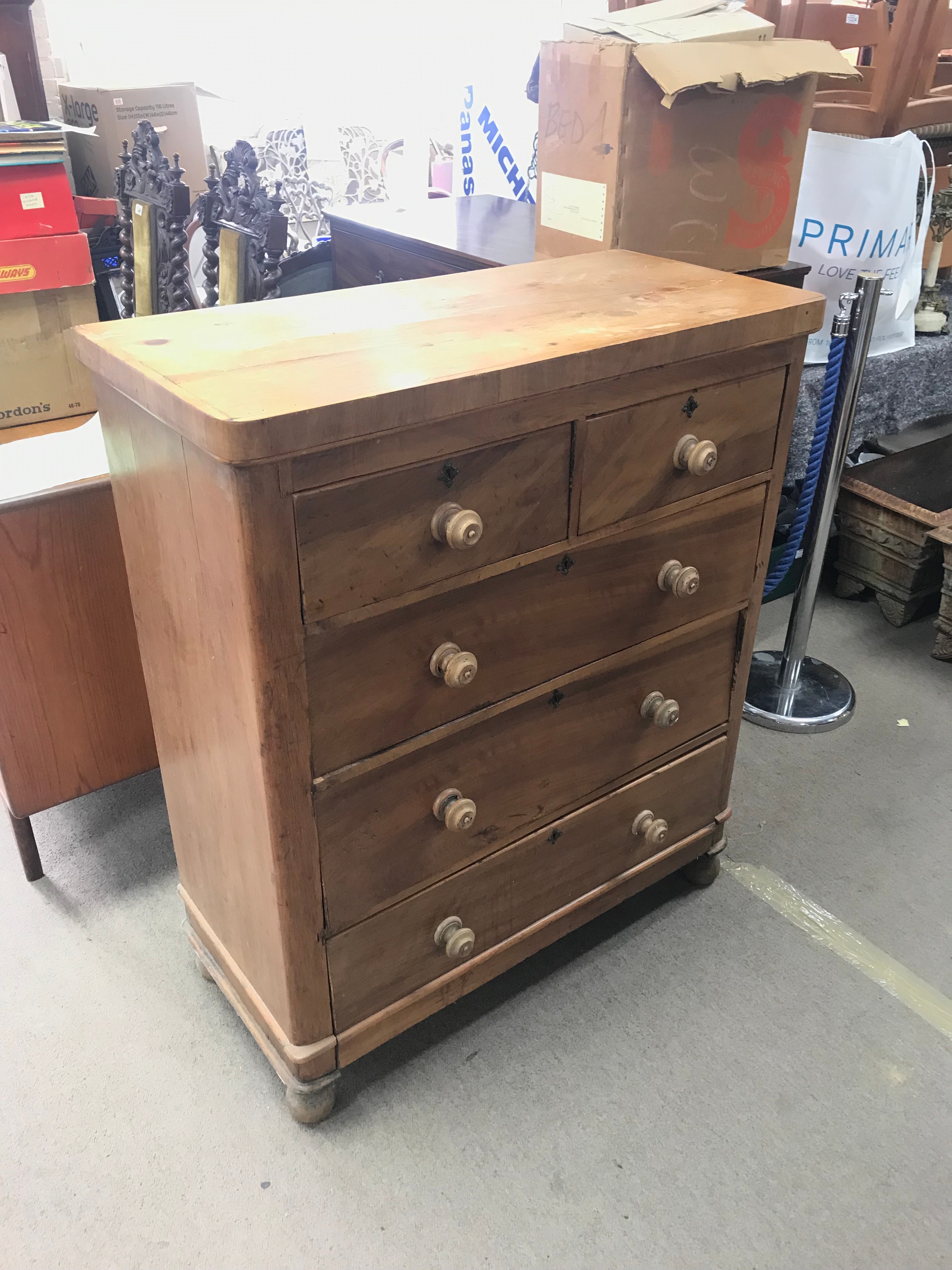 A pine chest of drawers featuring a traditional two-over-three drawer configuration with turned wooden knobs and key escutcheons. 94cm wide, 44cm long 111cm tall