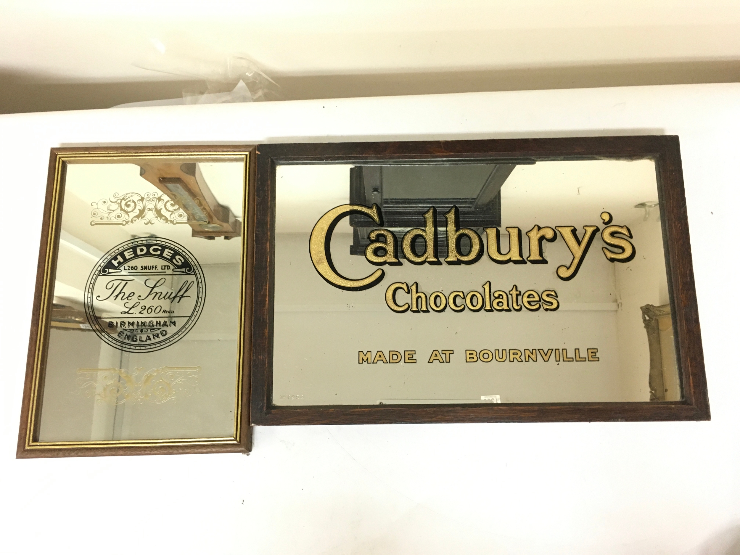 Two vintage advertising mirrors Cadbury chocolates made in Bournville (45x30cm) and Hedges The Snuff (23x33cm)