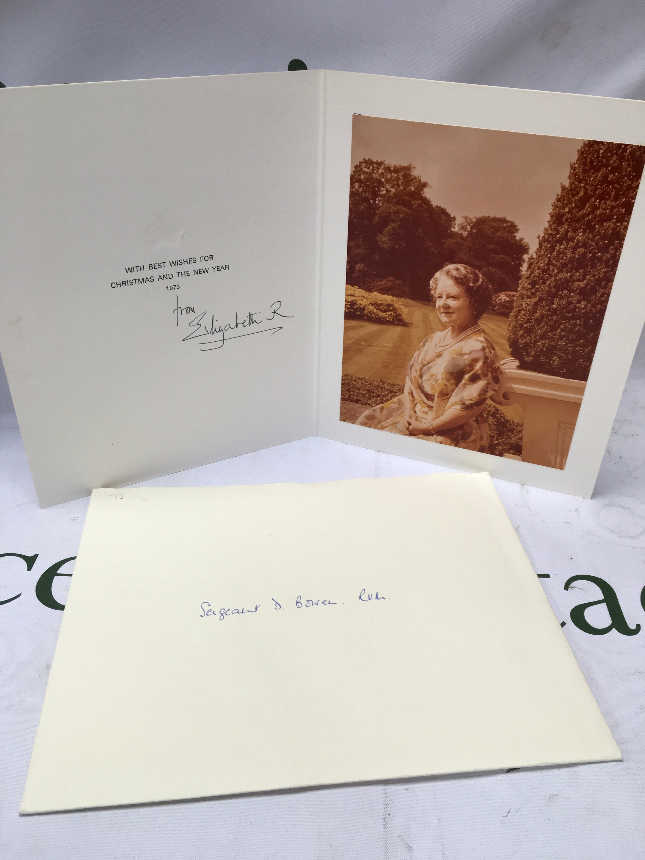 H.M. Queen Elizabeth (1900-2002) signed [autopen] Christmas card 1973, with colour photograph of Her Majesty seated with gardens beyond, signed in black both 'from Elizabeth R', 186mm x 235mm and with envelope [hand delivered Clarence House], card appear to be in good condition.