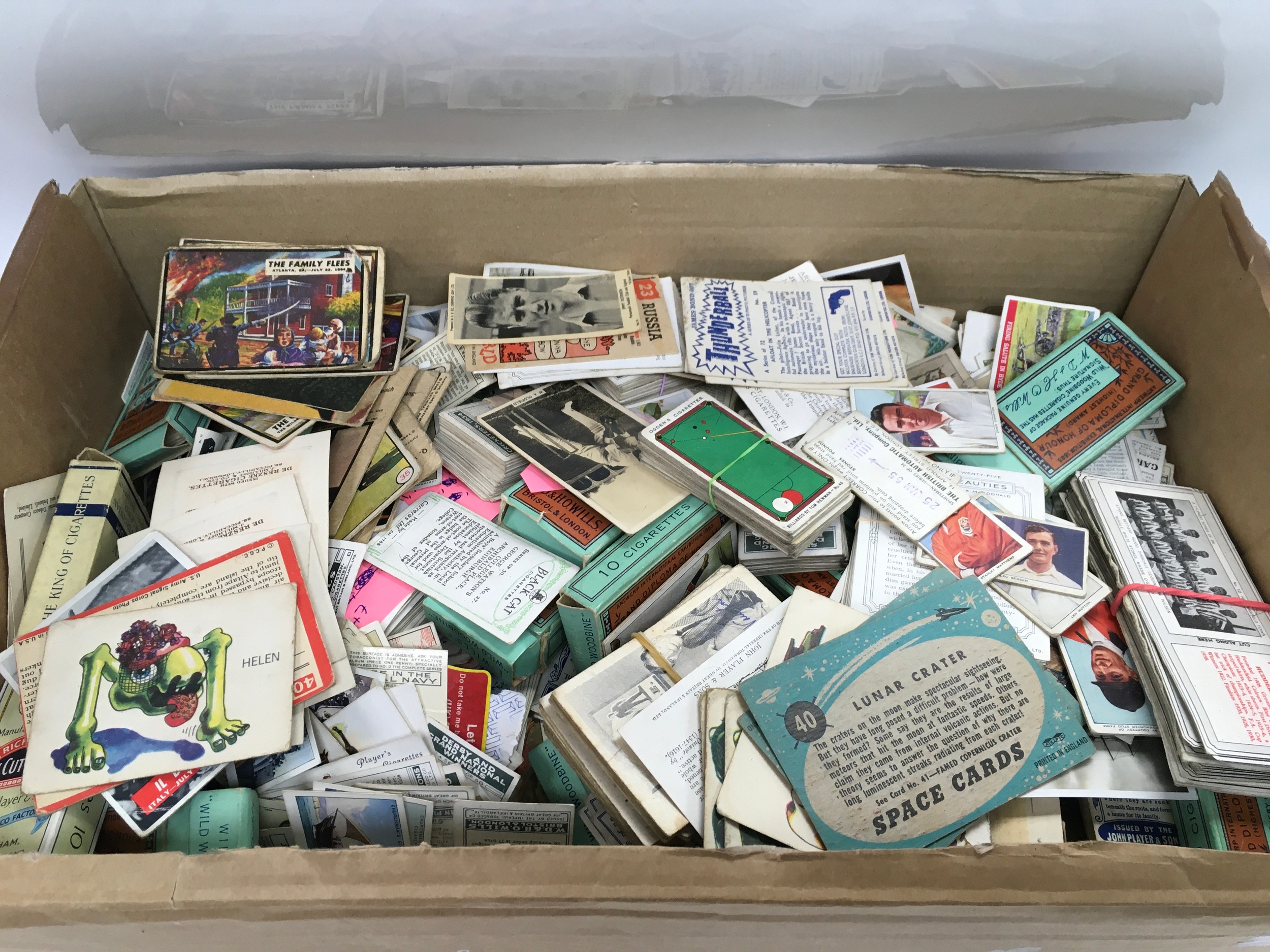box containing a large collection of vintage trade cards, including cigarette cards and tea cards from various