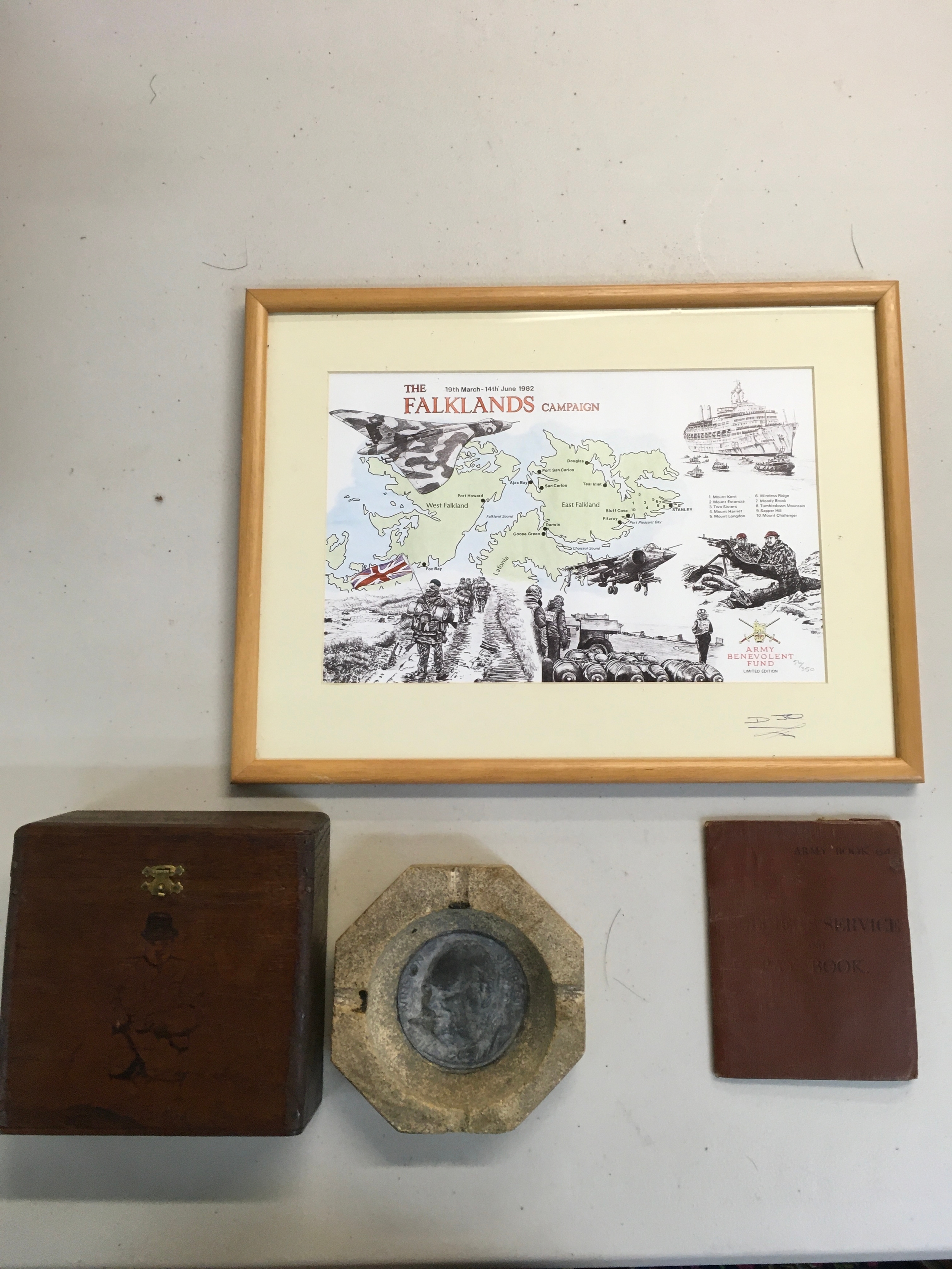 Falklands map, Paybook, and a octagonal stone featuring a Churchill medal in the middle