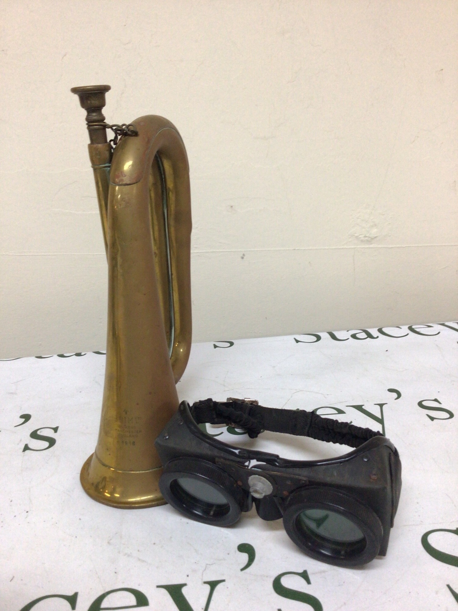 A Military issue brass bugle and a pair of Polaroid type goggles possibly military (2)